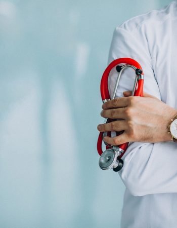 Young handsome physician in a medical robe with stethoscope